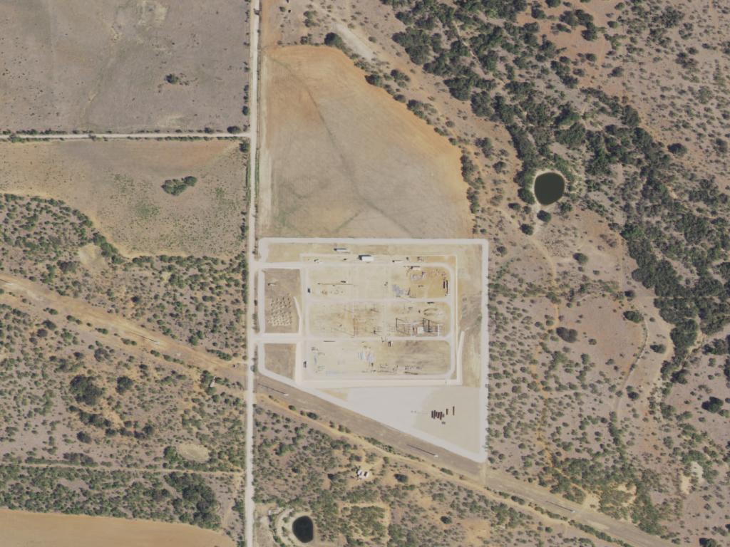 Aerial view of the Roadrunner Crossing site: a large equipment pad beside cultivated fields in West Texas.
